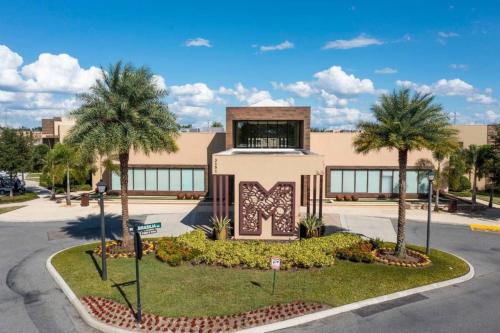 Spacious 4-Suite Villa with Balcony, Magic Village في أورلاندو: مبنى فيه نخيل قدام شارع