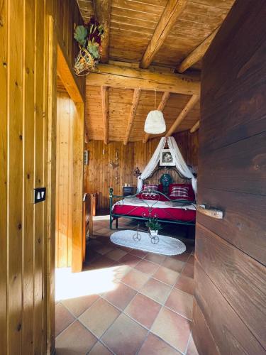 1 dormitorio con cama roja en el techo de madera en Baita RosiCin, en Paisco