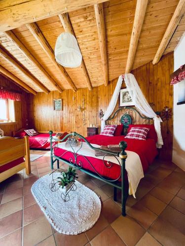 Un dormitorio con una cama roja en una habitación con techos de madera. en Baita RosiCin, en Paisco