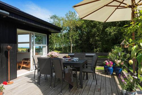 a wooden deck with a table and an umbrella at 30074-Malling-Musvitvej-4 in Malling