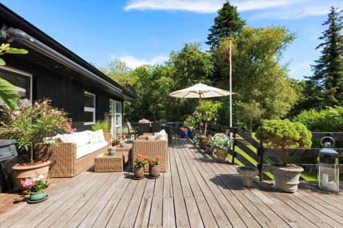 a wooden deck with a couch and an umbrella at 30074-Malling-Musvitvej-4 in Malling