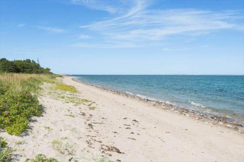 a sandy beach next to the ocean on a clear day at 30074-Malling-Musvitvej-4 in Malling