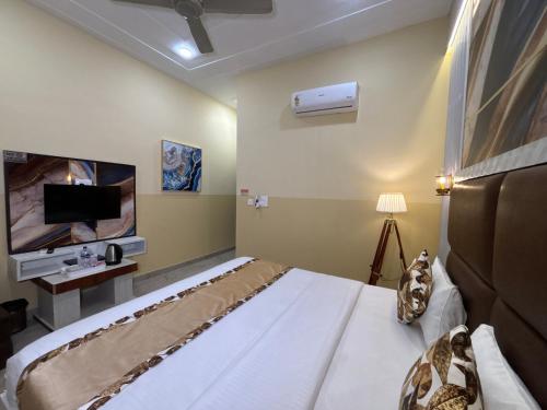 a bedroom with a large bed and a flat screen tv at The Orchid Retreat in Agra