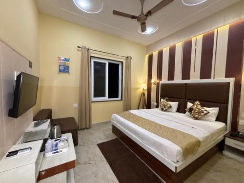 a hotel room with a bed and a television at The Orchid Retreat in Agra