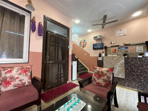 a living room with two chairs and a glass table at The Orchid Retreat in Agra