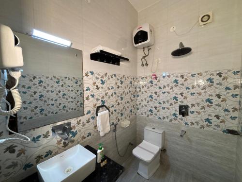 a bathroom with a white toilet and a sink at The Orchid Retreat in Agra