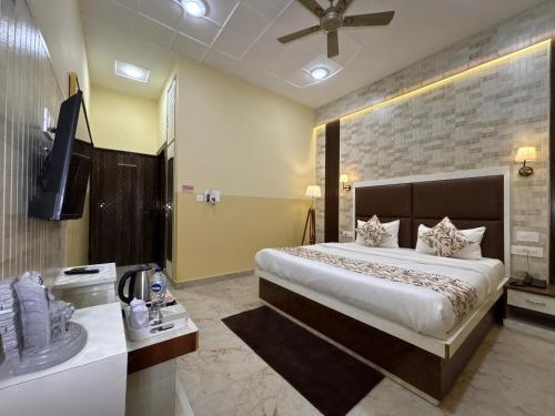 a bedroom with a large bed and a television in it at The Orchid Retreat in Agra
