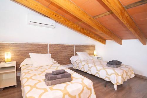 two beds in a room with wooden ceilings at 113 Finca Can Roig ETV955 by Mallorca Charme in Alcudia