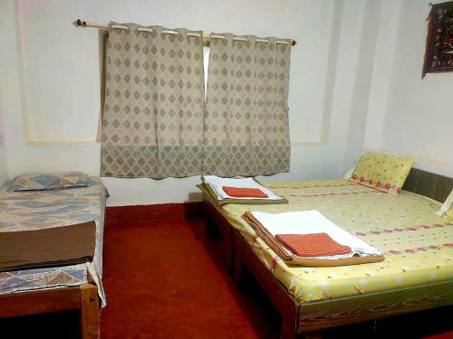 a room with two beds and a window at Naturecraft Homestay in Vastāra