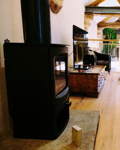 a wood stove in a living room with a mirror at Tithe Barn, Skipton in Skipton