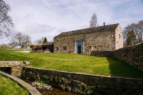 an old stone house with a stone wall at Tithe Barn, Skipton in Skipton