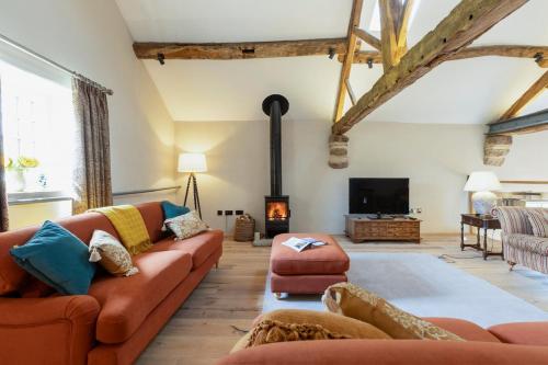 a living room with a couch and a fireplace at Tithe Barn, Skipton in Skipton