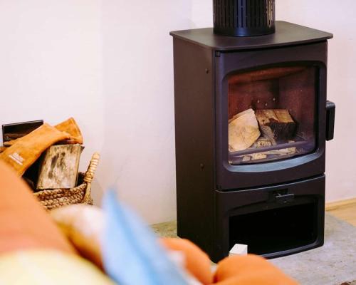 a wood burning stove sitting in a living room at Tithe Barn, Skipton in Skipton