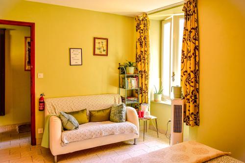 a living room with a couch and a window at Les deux arches in Caunes-Minervois