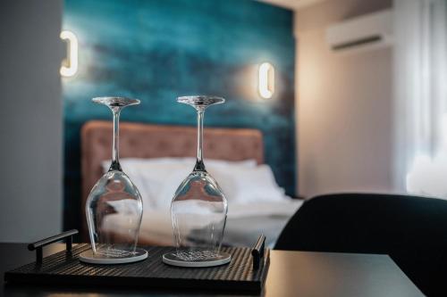 two wine glasses sitting on a table in a room at Hesmir's Nest in Tirana