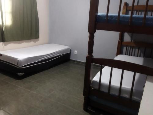 a room with two beds and a bunk bed at Casa completa para 4 pessoas in Itu