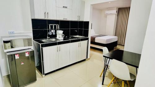 cocina con fregadero, mesa y nevera en 304 studio apartment in El Peñon, en Cali