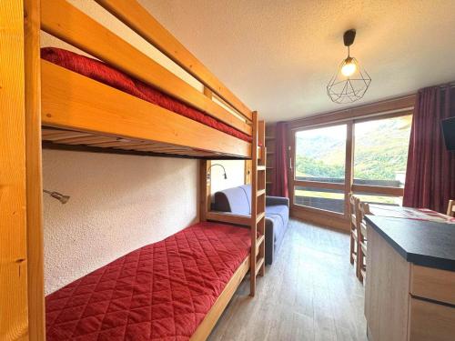a bedroom with two bunk beds and a kitchen at Studio lumineux avec balcon, au pied des pistes, Les Menuires – 3 personnes - FR-1-452-17 in Les Menuires