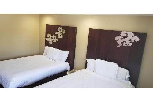 two beds in a room with white sheets at Century Motel Buena Park Anaheim CA 91 in Buena Park