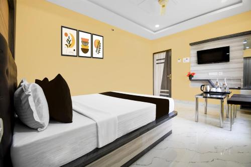 a bedroom with a bed and a desk and a television at Collection O Hotel Pearl Paradise in Puri