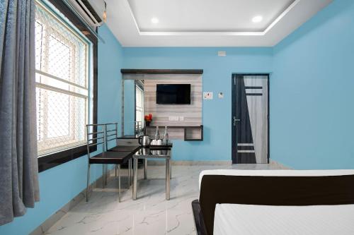 a bedroom with blue walls and a dining room at Collection O Hotel Pearl Paradise in Puri