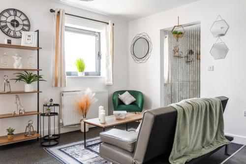 a living room with a chair and a table at Modern 1-Bedroom Apartment with Parking near Heathrow in Colnbrook