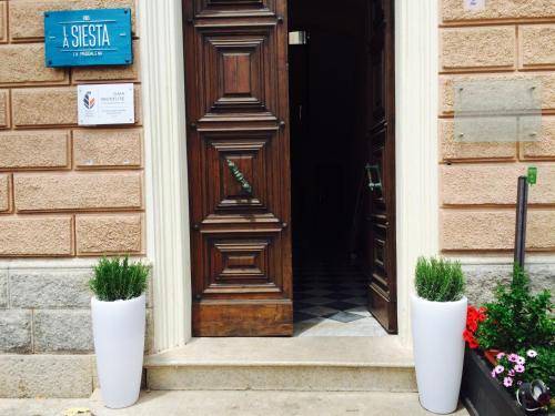 dos jarrones blancos sentados frente a una puerta en La Siesta en La Maddalena