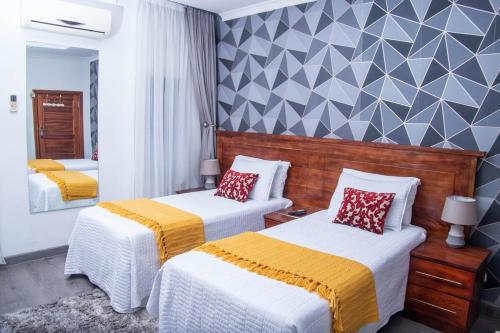 a hotel room with two beds and a mirror at La Consolata Villa Olympia Extension in Lusaka