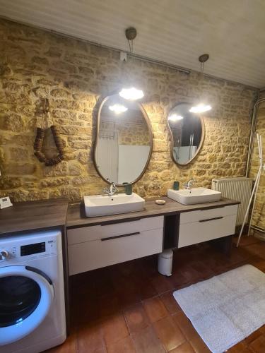 a bathroom with two sinks and a washing machine at La Chartreuse Carmille in Domme