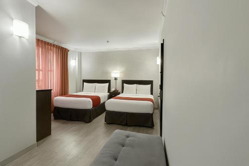 a hotel room with two beds and a couch at Heritage Hotel New York City in New York