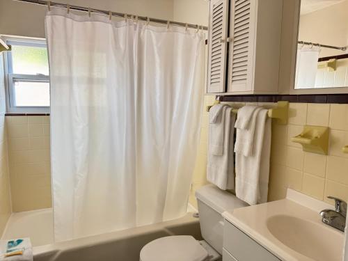 a bathroom with a white shower curtain and a sink at Tropical Villas Of Venice Beach in Venice