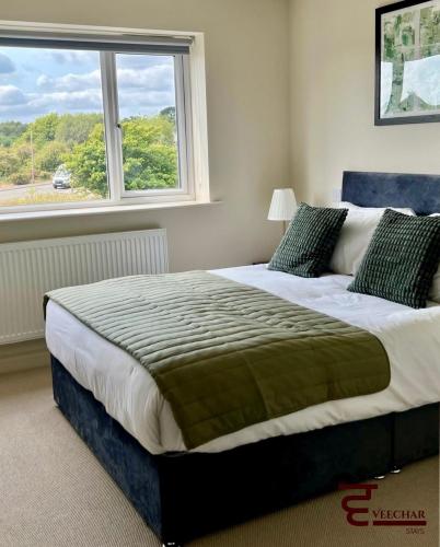 a bedroom with a large bed with a window at Spacious 4BR Home New Forest-Parking & Pet Friendly in Lymington