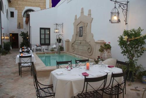 een tafel op een binnenplaats met een zwembad bij La Casona de Calderón Gastronomic & Boutique Hotel in Osuna