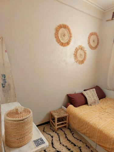 a bedroom with a bed and a basket on the wall at Moroccan Boho Surf House in Agadir