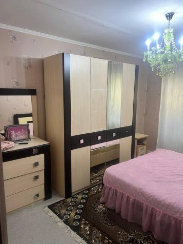 a bedroom with a bed and a dresser and a mirror at Family Stay Karakol in Karakol