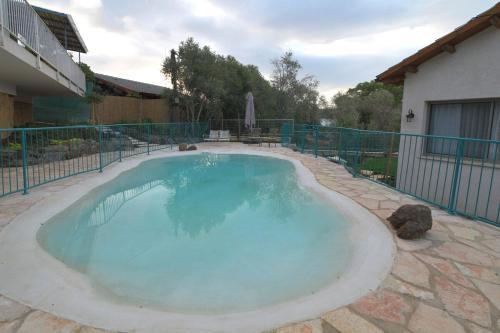 a large pool with blue water in a yard at חווייה של שקט- מתחם שלם עם בריכה- רק בשבילכם in Livnim