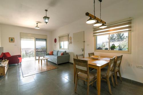 a dining room and living room with a table and chairs at חווייה של שקט- מתחם שלם עם בריכה- רק בשבילכם in Livnim