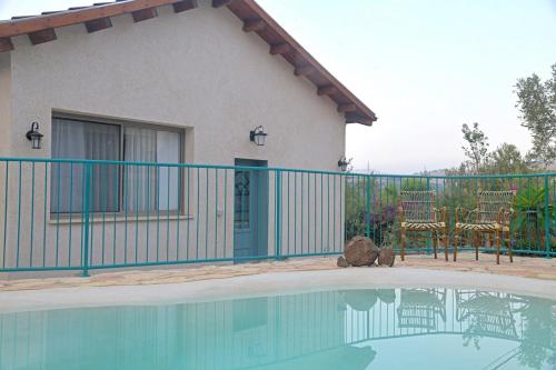 a house with a fence next to a swimming pool at חווייה של שקט- מתחם שלם עם בריכה- רק בשבילכם in Livnim