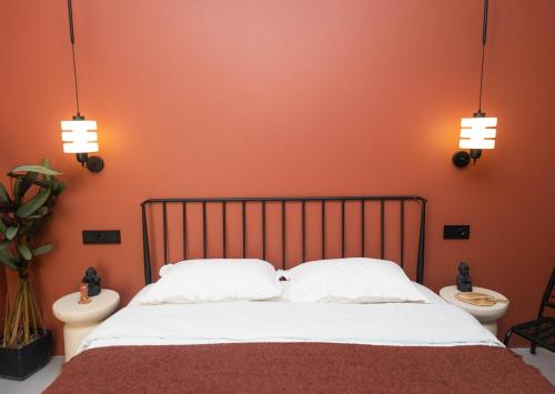 a bedroom with orange walls and a bed with two toilets at Ruby Hostel - Lux Group Dorm Rooms in Kutaisi