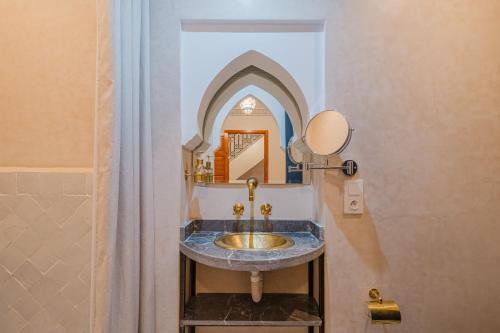 a bathroom with a sink and a mirror at Riad Dar Z'r in Marrakech