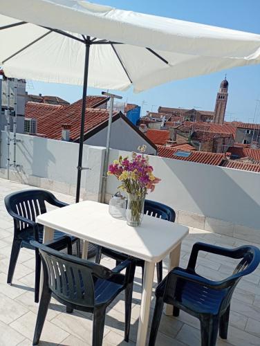 a white table and chairs with a white umbrella at Casa AnnaPaola Luxury in Chioggia