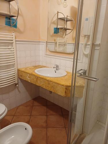 a bathroom with a sink and a mirror and a toilet at Hotel L'AQUILA 99 in LʼAquila