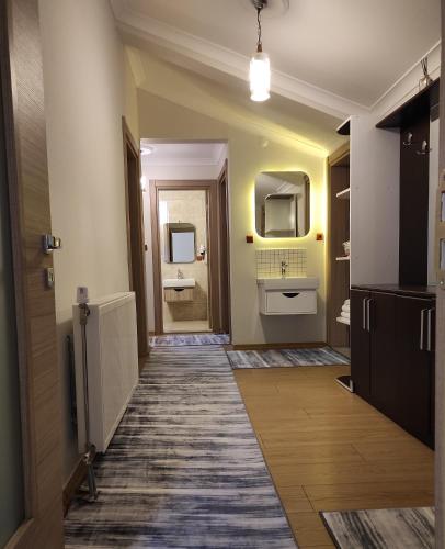 a bathroom with a hallway with two sinks and a mirror at Uzungol Apart in Uzungöl