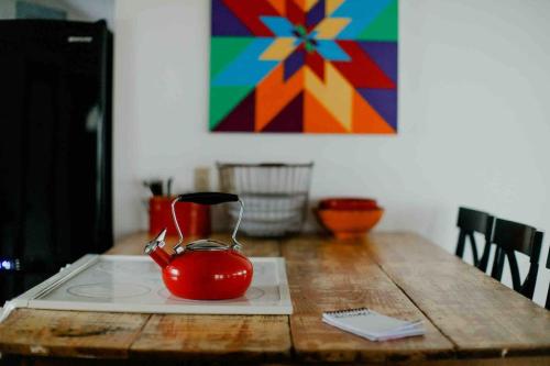a red tea kettle sitting on top of a wooden table at Cozy Oasis by Lake MI with Hot Tub in Harbert