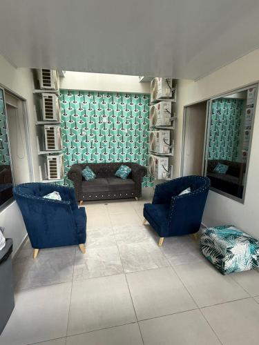 a living room with two blue chairs and a couch at HOTEL VILLAREAL VILLAVICENCiO in Villavicencio