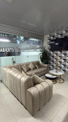a living room with a large couch and a table at HOTEL VILLAREAL VILLAVICENCiO in Villavicencio