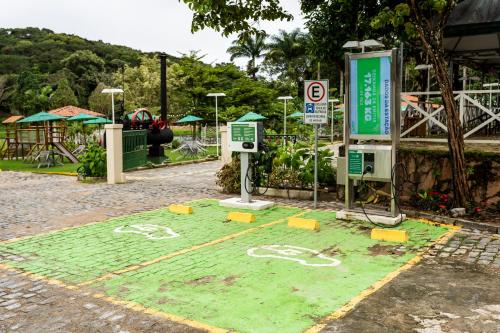 a parking lot with green grass and a sign at Pousada do Lago in Guaramiranga