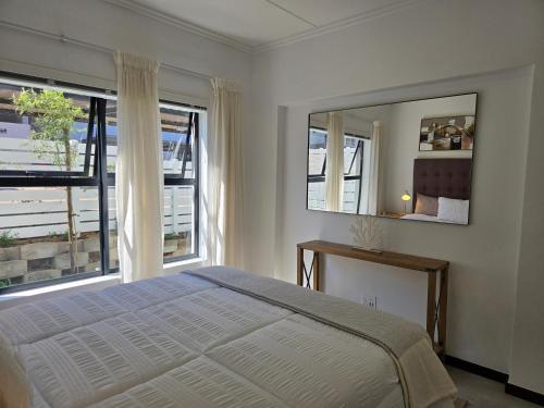 a bedroom with a bed and two large windows at The One One Two in Sandton