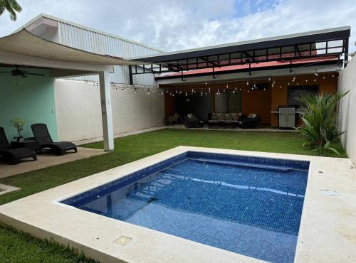 a swimming pool in the yard of a house at Hermosa Beach in Tapantí