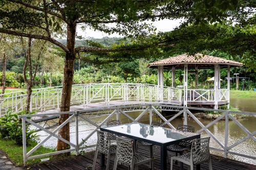 a table and chairs in front of a gazebo at Pousada do Lago in Guaramiranga